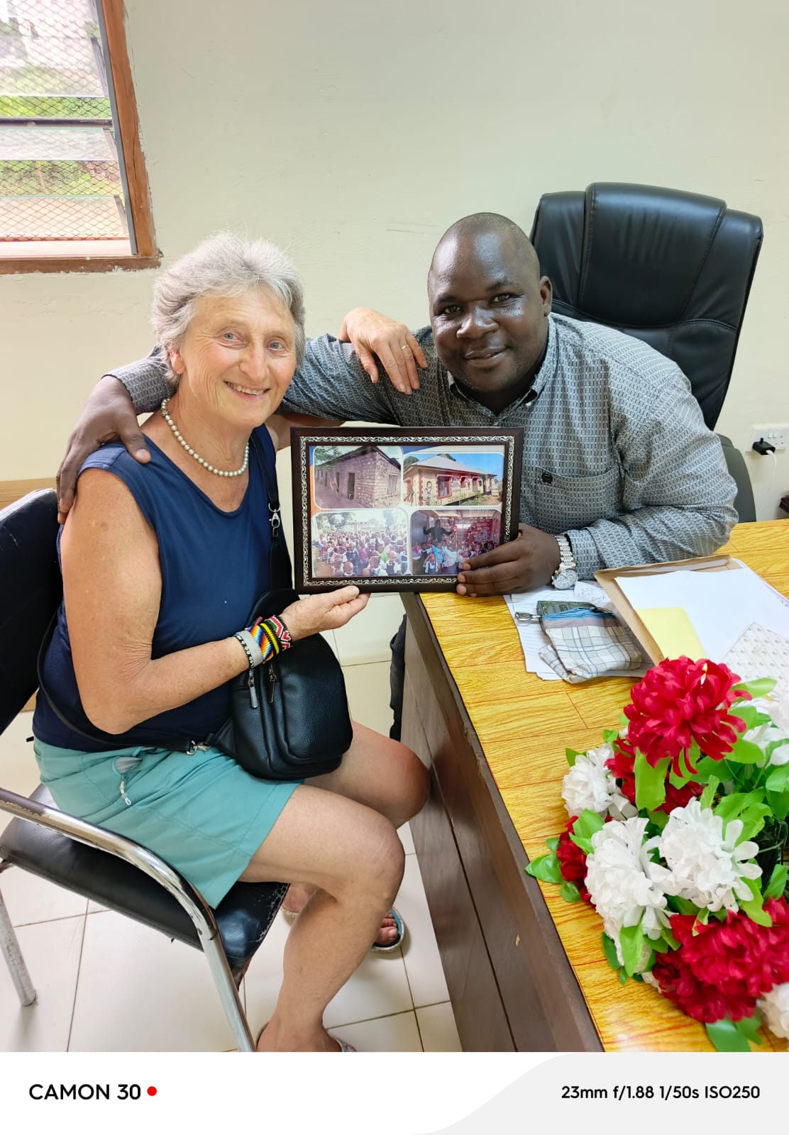 Rosemarie Pscheid and Director Johnstone Mdavan Maelo holding a framed photo together