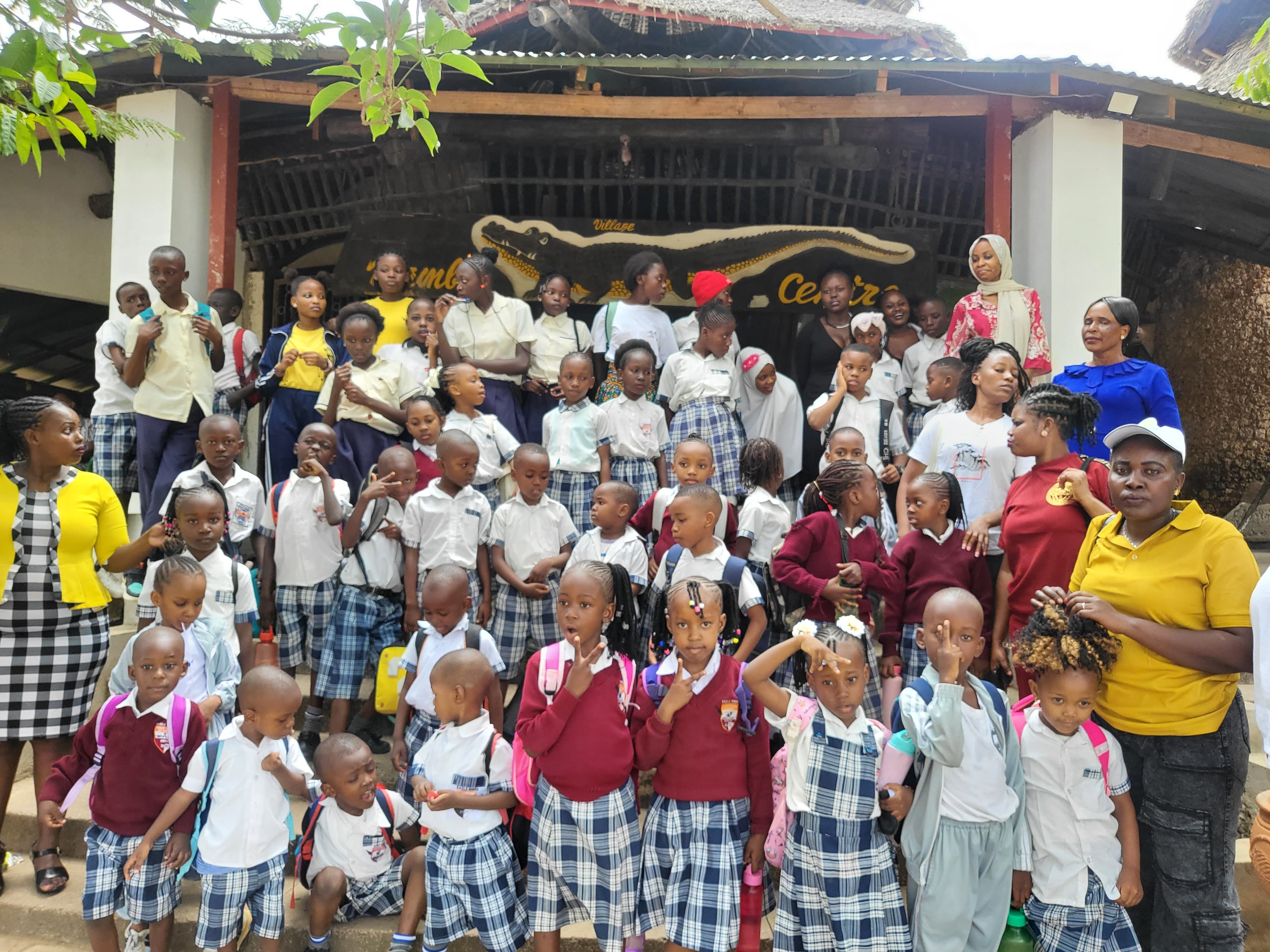 Full class and staff group photo at Mamba Village entrance during school trip