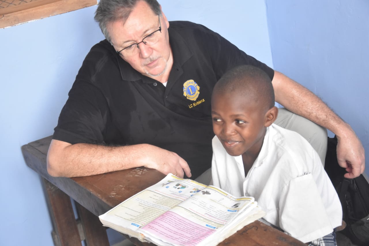 A volunteer reading with a student at Eagle Wings Lighthouse Academy